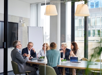 Mehrere Personen besprechen sich in einem Meetingraum