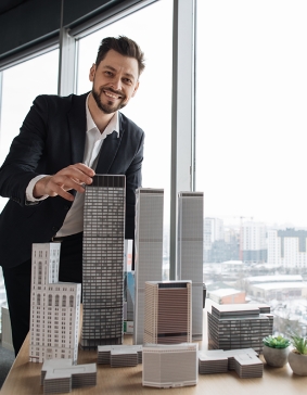 Person an einem Modell von einem Hochhaus